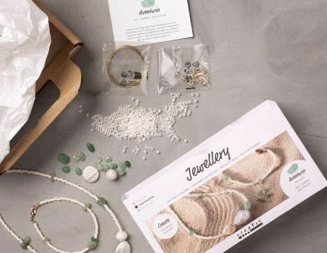 Schmuck-DIY-Sets wurden geöffnet und der Inhalt auf einem Tisch ausgestellt