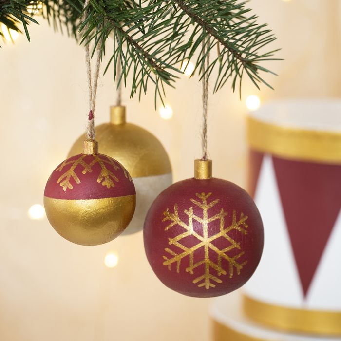 Hölzerne Christbaumkugeln, verziert mit Bastelfarbe und Plus Color-Markern