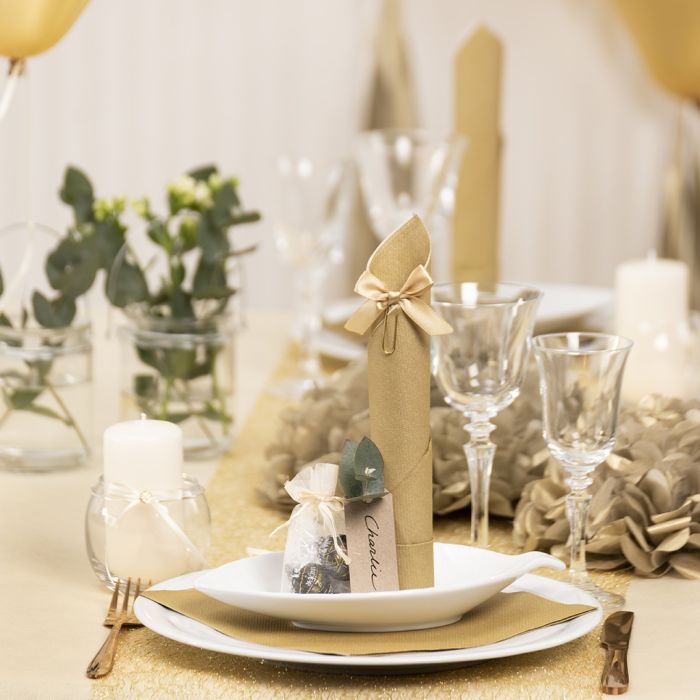Tischdeko in Gold mit Papierblumen, Luftballons, zum Turm gefaltete Serviette und Platzkarten