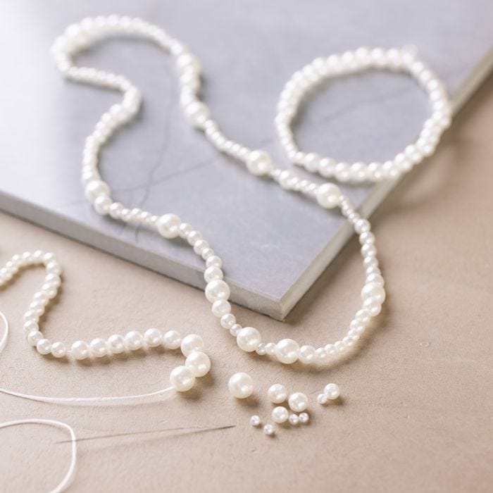 Halskette und Armband mit perlmuttweißen Perlen