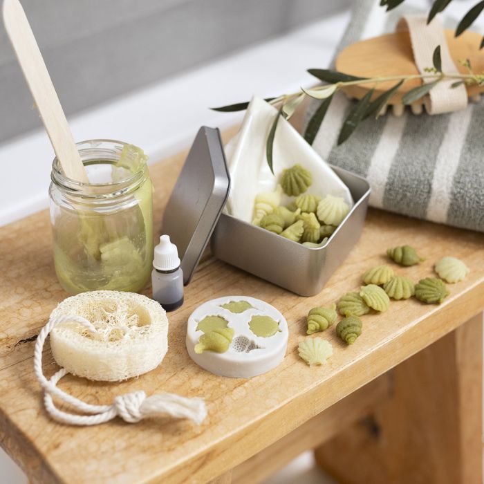 Reisedose mit kleinen Olivenölseifen und Loofah-Schwamm