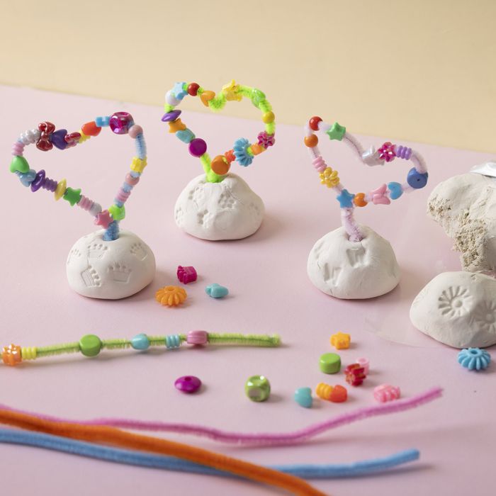 Pfeifenreiniger und Perlenherz auf einem Tonsockel