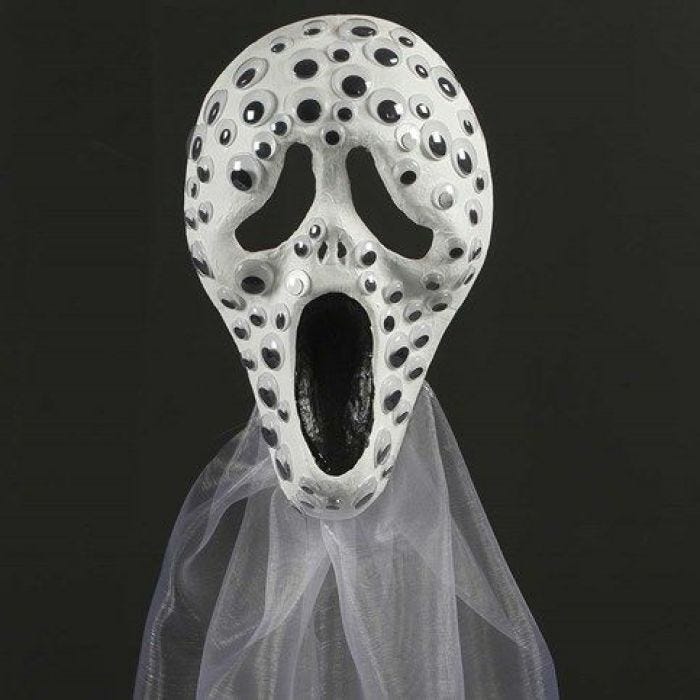 A Scream mask decorated with wiggle Eyes and Organza