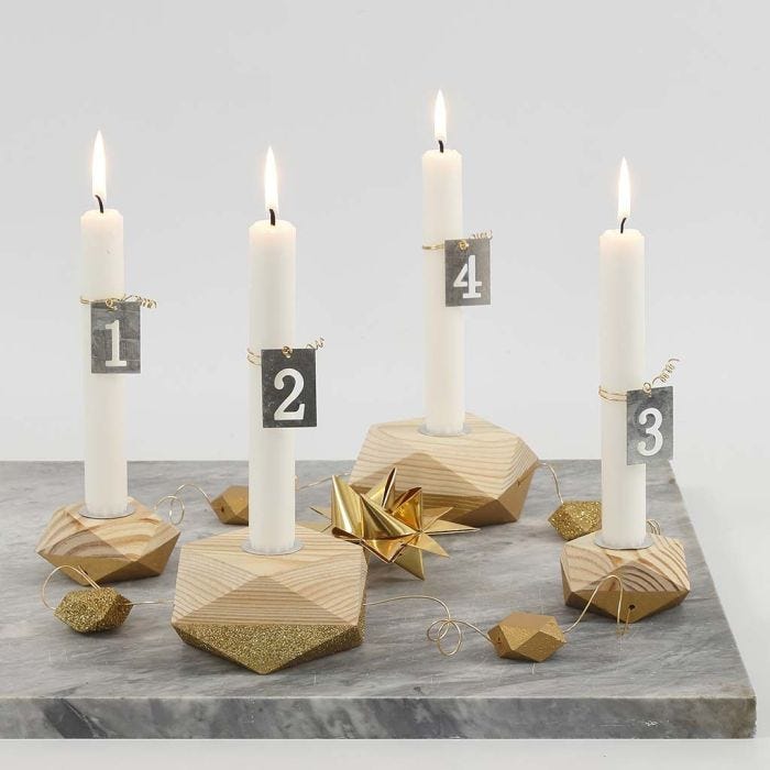 Ein Adventskranz mit vier, teils mit goldener Farbe bemalten, Kerzenhaltern