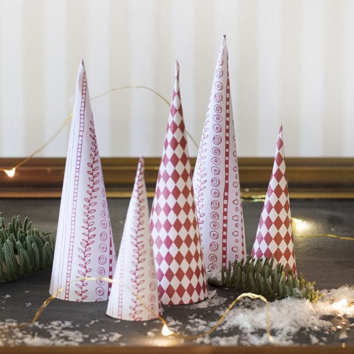 Kegelförmige Weihnachtsbäume, gebastelt aus Design-Papier