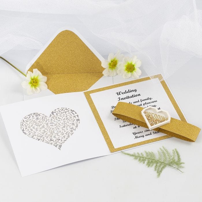 Hochzeitseinladung, gebastelt aus goldenem Glitzerpapier, verziert mit herzförmigen Shaker Stickern