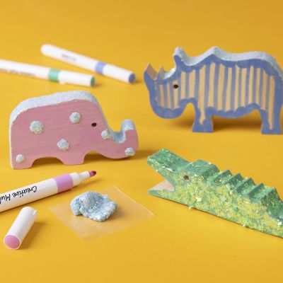 Holztiere mit Markern und Glitter Clay dekoriert
