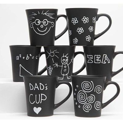 Schwarze Tassen verziert mit weißen Glas- und Porzellanmarkern