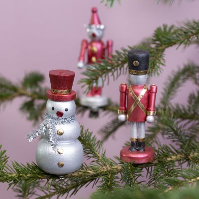Weihnachtliche Holzfiguren auf Metallklammern