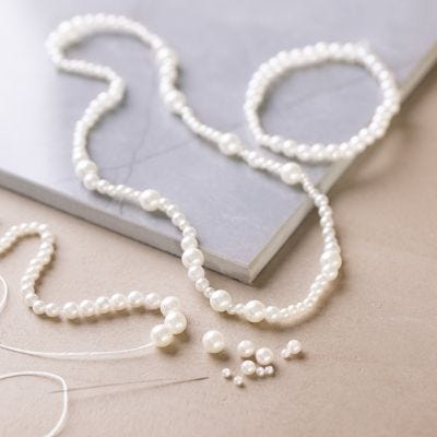 Halskette und Armband mit perlmuttweißen Perlen