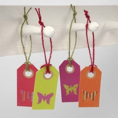 Aus Design-Papier gestanzter Schmetterling auf Geschenkanhänger