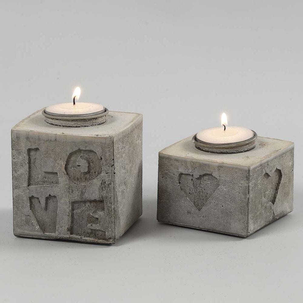 Aus Betonmasse gegossener Kerzenhalter mit Relief aus Buchstaben und Zahlen