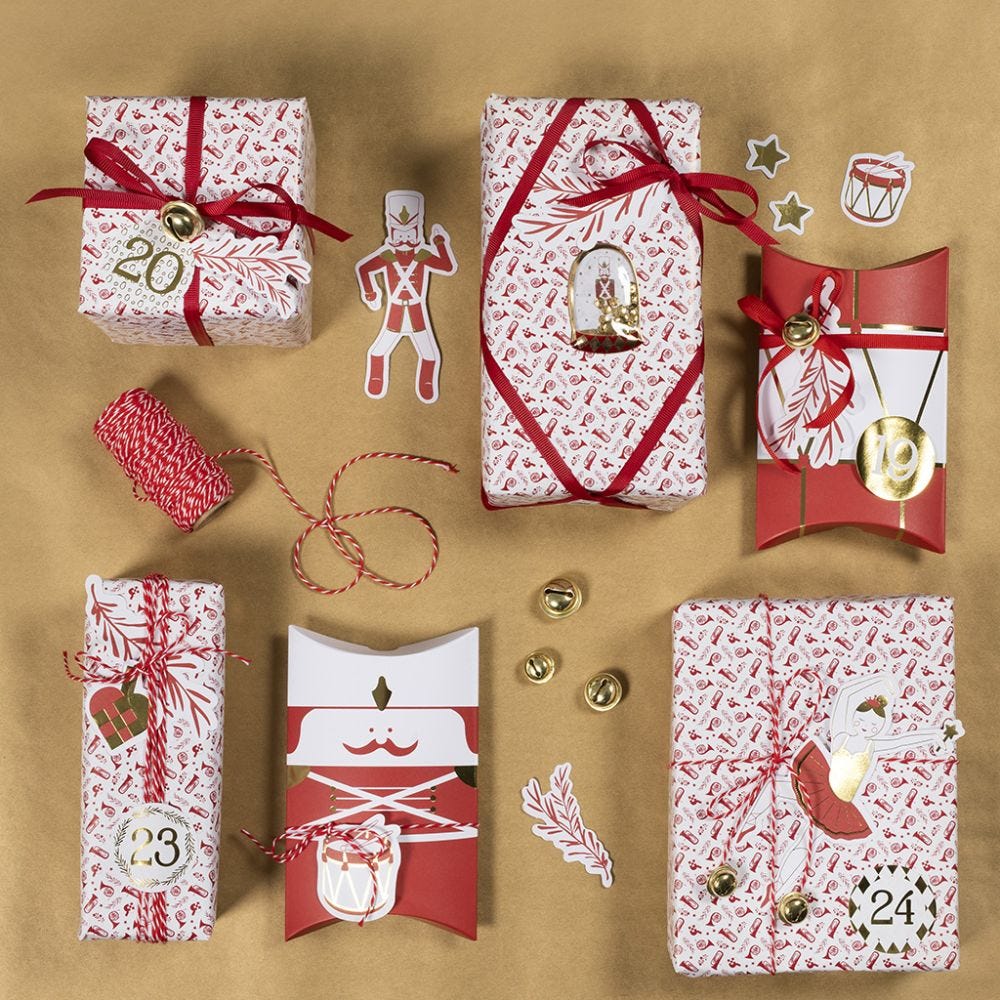 Weihnachtliche Geschenkverpackung, verziert mit Glöckchen, Stickern und Stanzmotiven